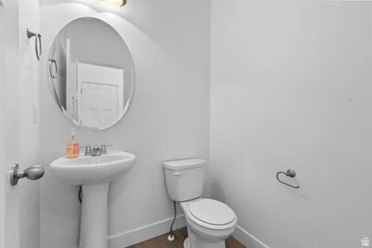 Pedestal sink with a polished chrome faucet, complementing the overhead vanity light fixture