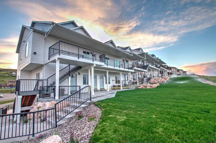 Modern multi-story residential complex featuring contemporary siding and multiple private balconies with black railings