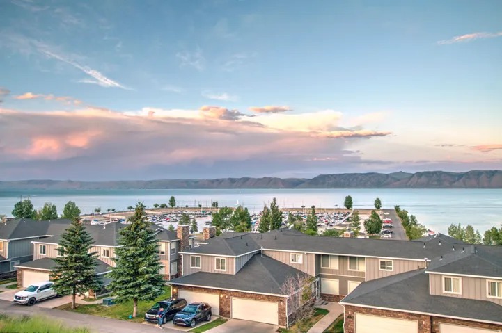 Waterfront community featuring multi-story residences with attached garages and stone veneer accents
