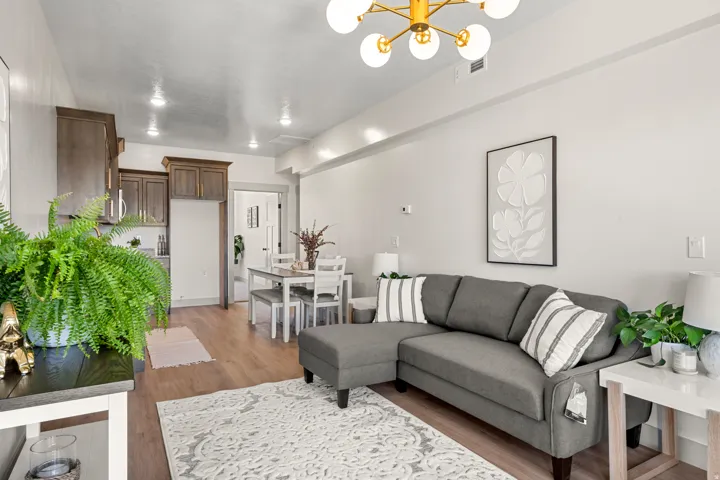 Open-concept living area with wood-finish flooring, a modern chandelier, and recessed lighting