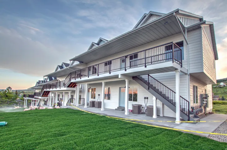 Multiple-unit structure featuring white horizontal siding and individual second-story balconies with black railings