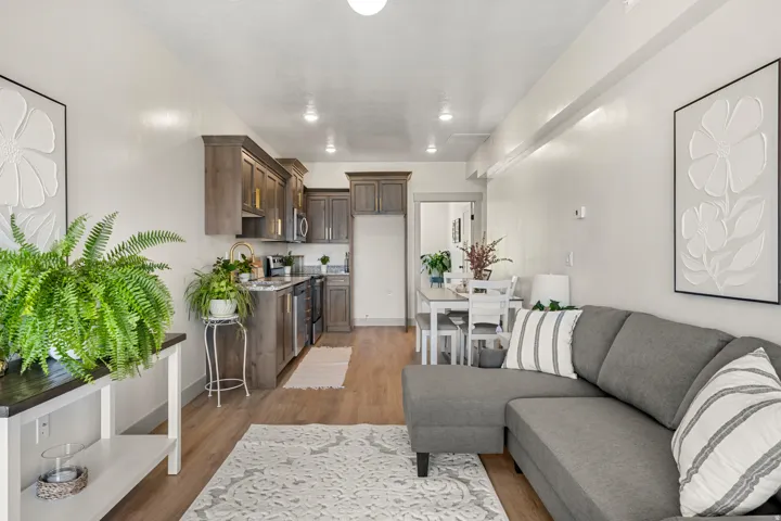 Open-concept living space featuring wood-finish flooring, recessed lighting, a kitchen with stainless steel appliances and wood cabinetry, and a dining area