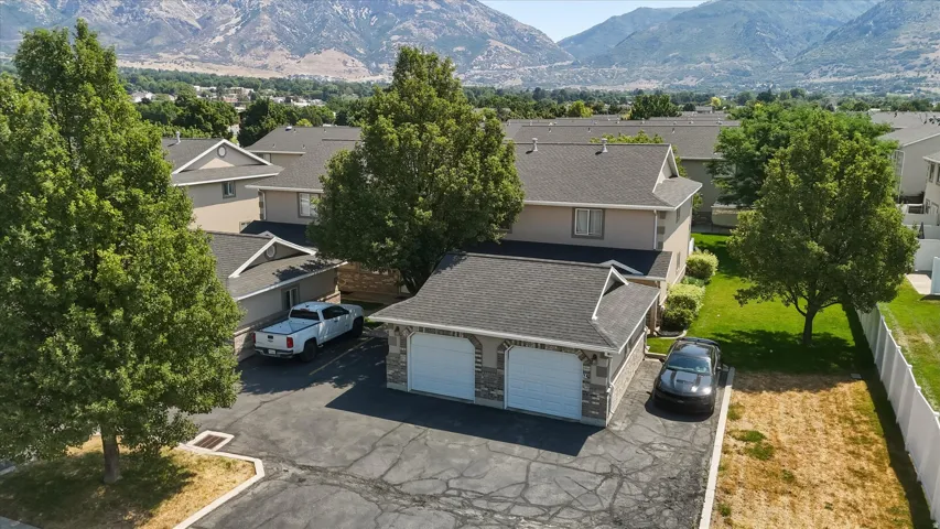 Two-story townhome featuring a dark shingle roof and beige siding