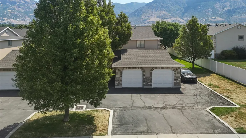 Two-car garage with stone veneer accents and a paved driveway