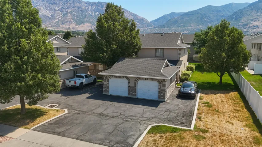 Two-story residence featuring a two-car attached garage with stone veneer accents and white garage doors