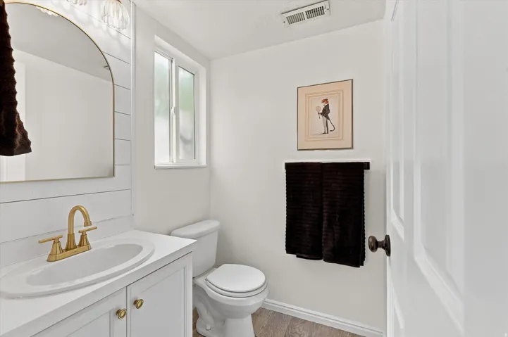 White vanity with brass hardware and gold-finish faucet