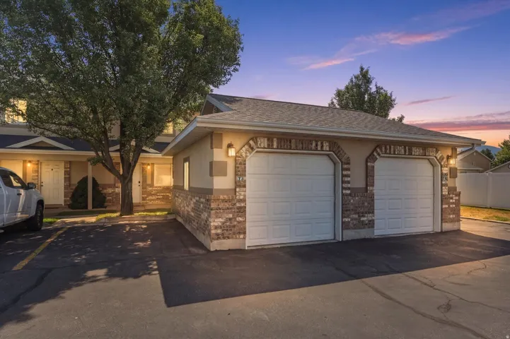 Two-car garage featuring arched brick accents and two paneled garage doors