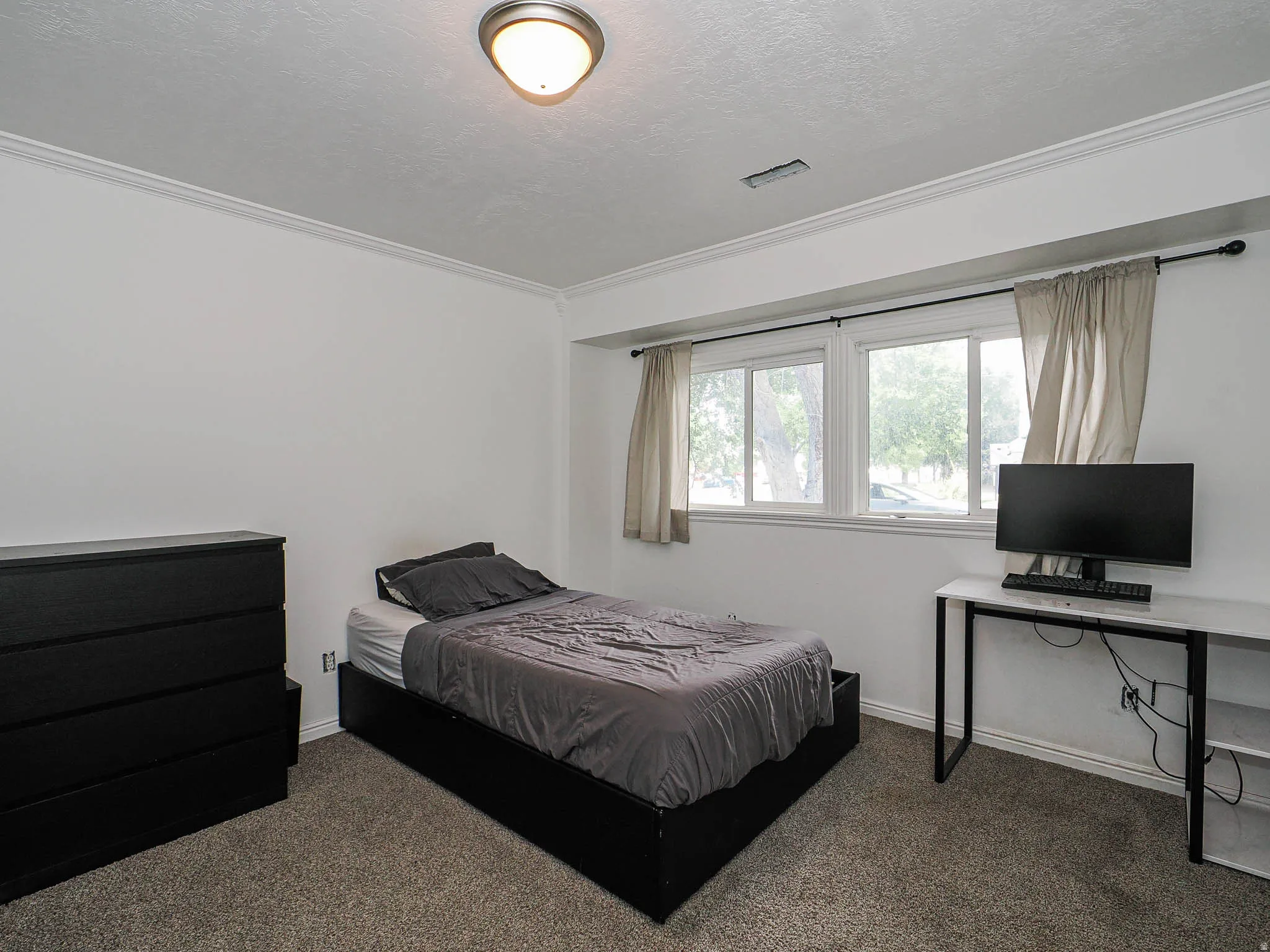 Room featuring white walls, crown molding, and a dual-pane window with white trim