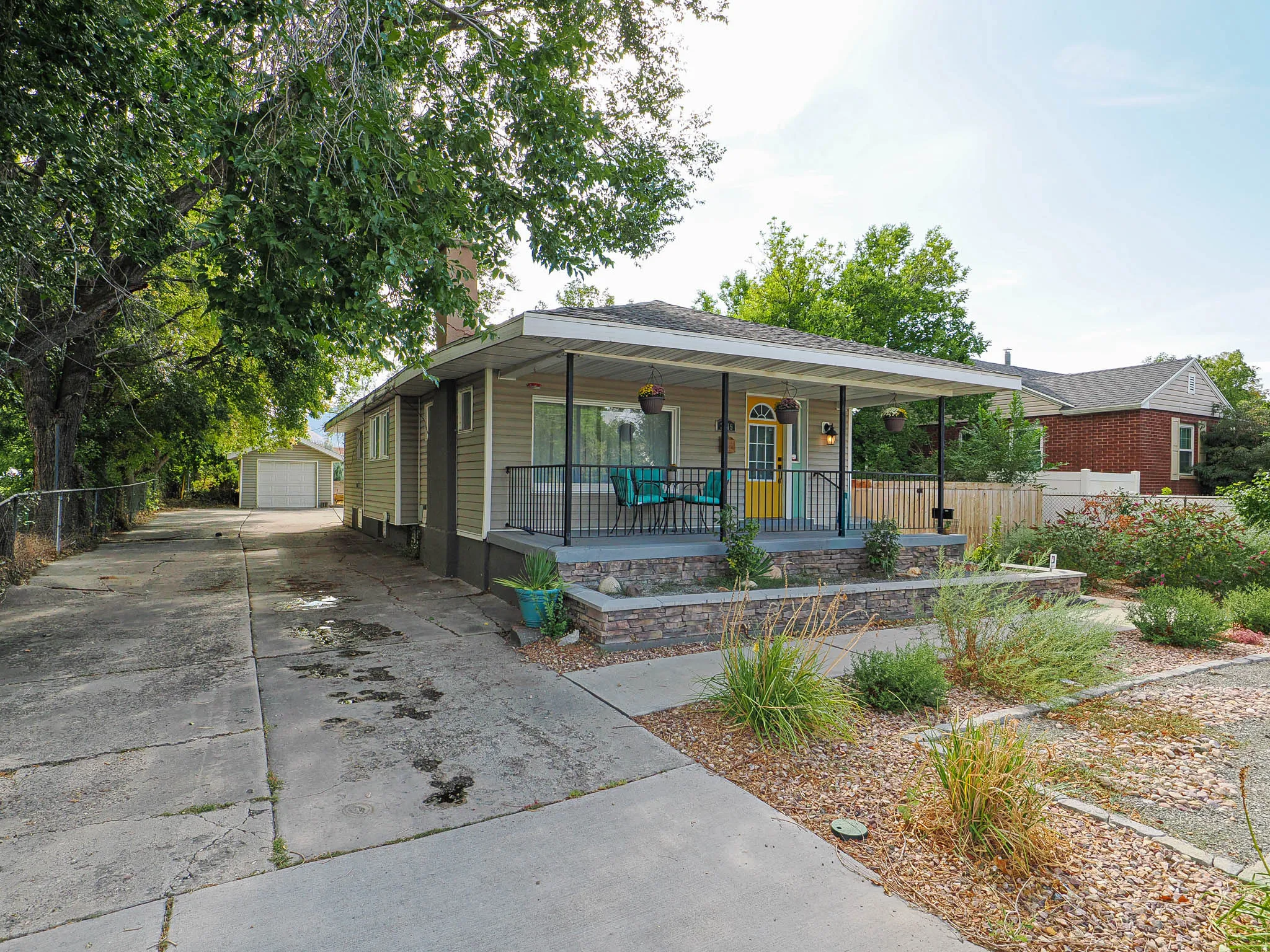 Ranch-style exterior featuring light-colored siding and a covered front porch with black railings