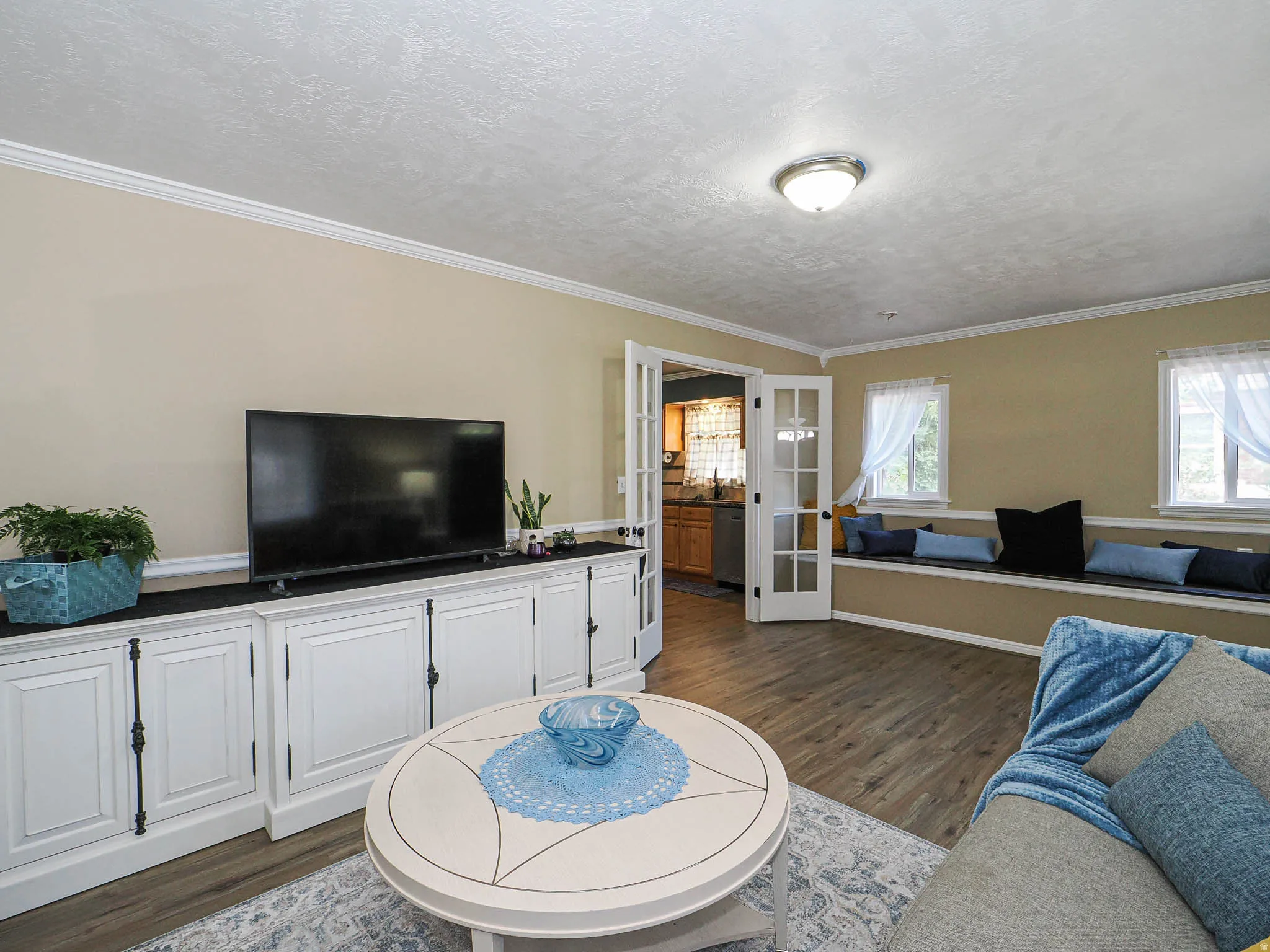 Living area featuring wood-finish flooring and crown molding