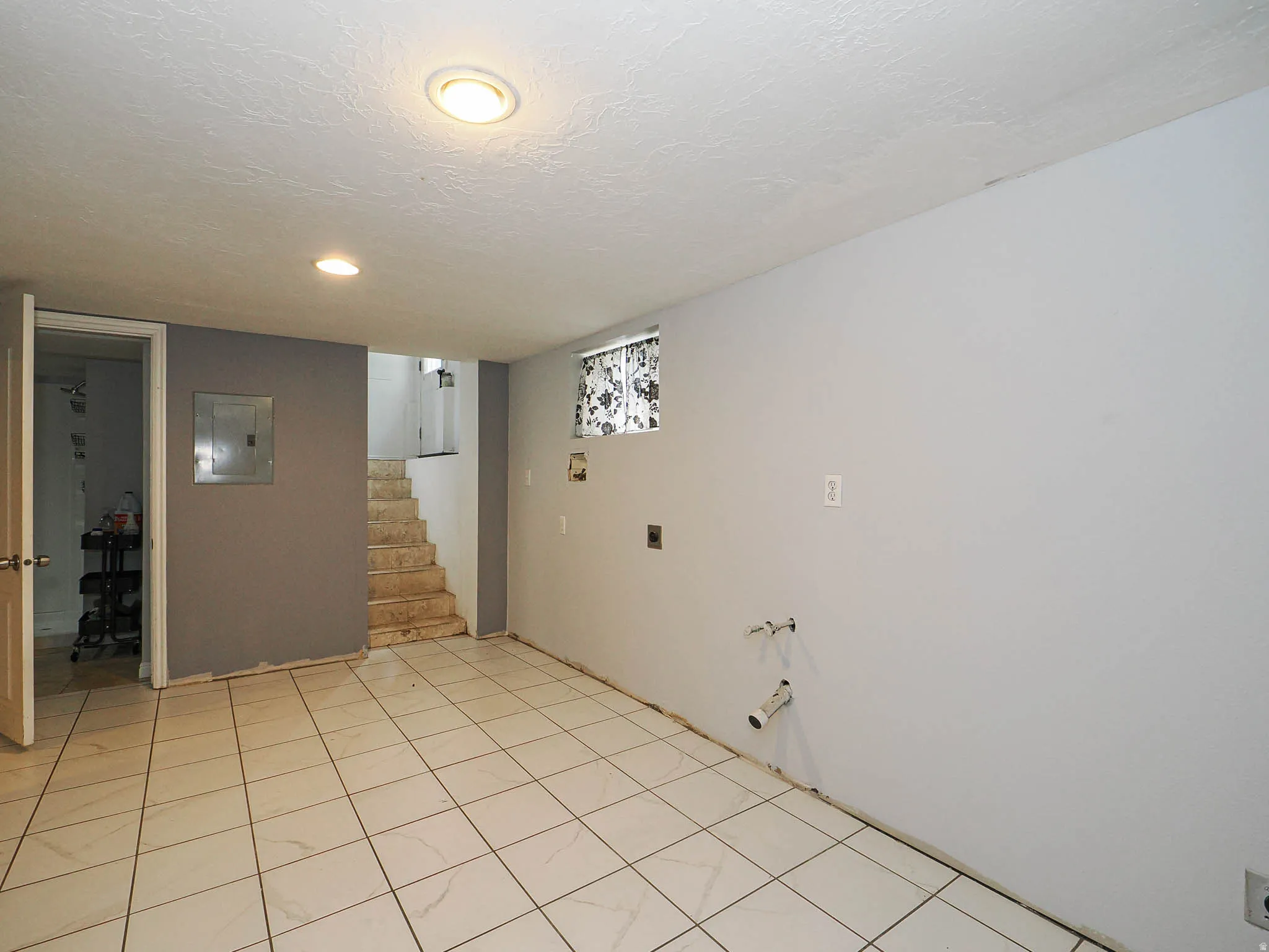 Spacious room featuring tile flooring, neutral wall tones, and recessed lighting