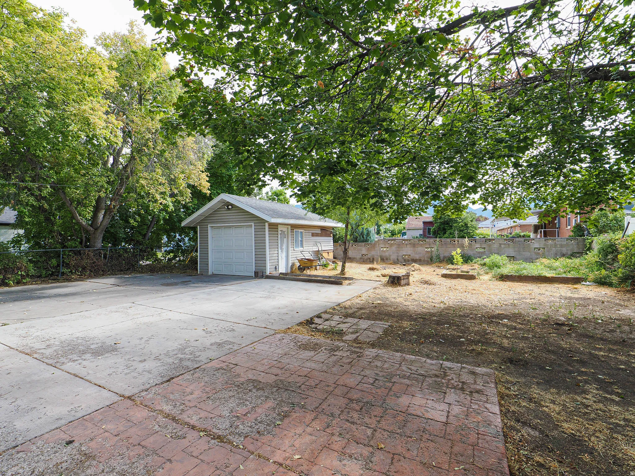 Detached outbuilding with vinyl siding and a roll-up garage door
