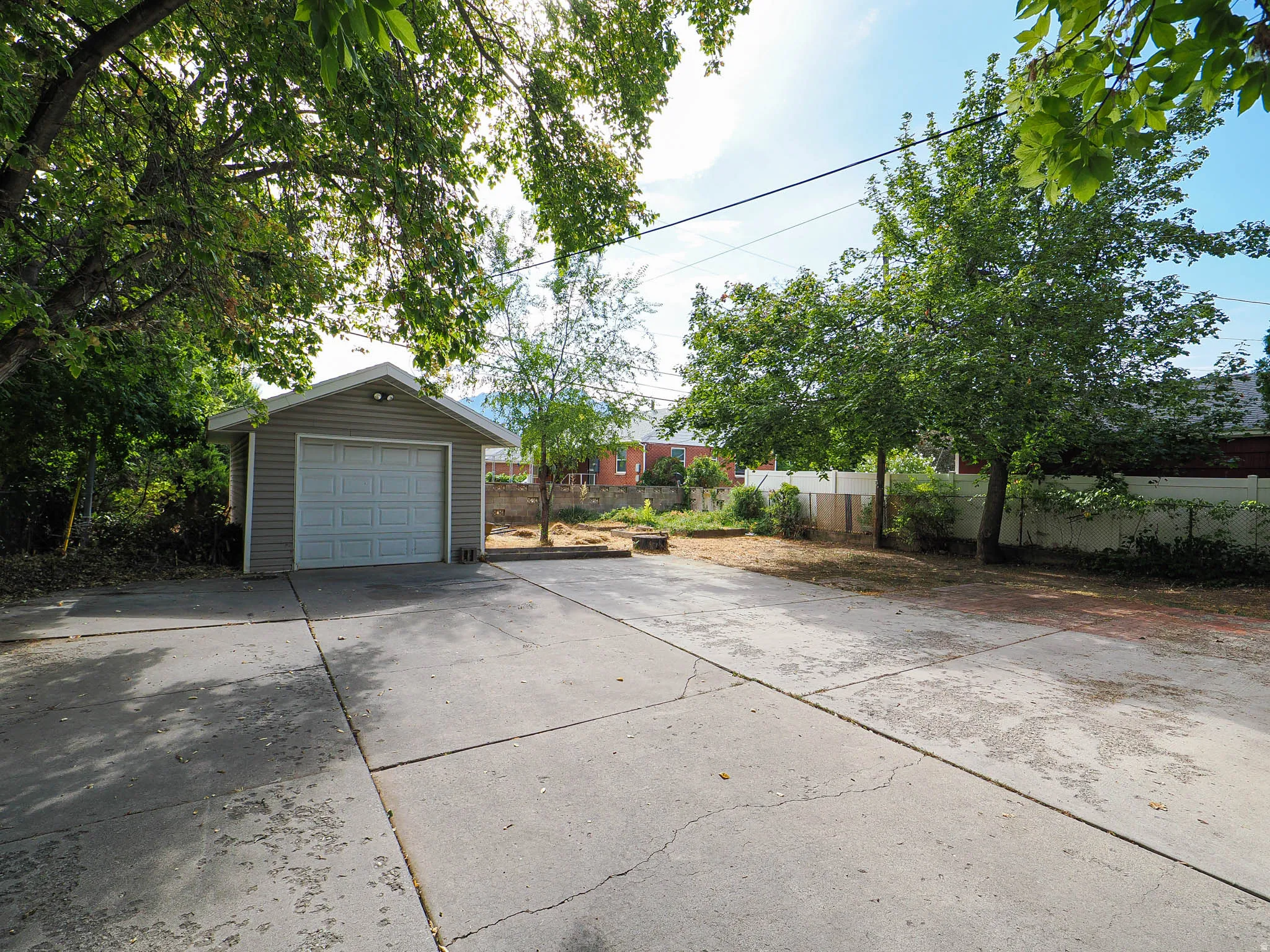 Detached garage featuring panel siding and an overhead garage door