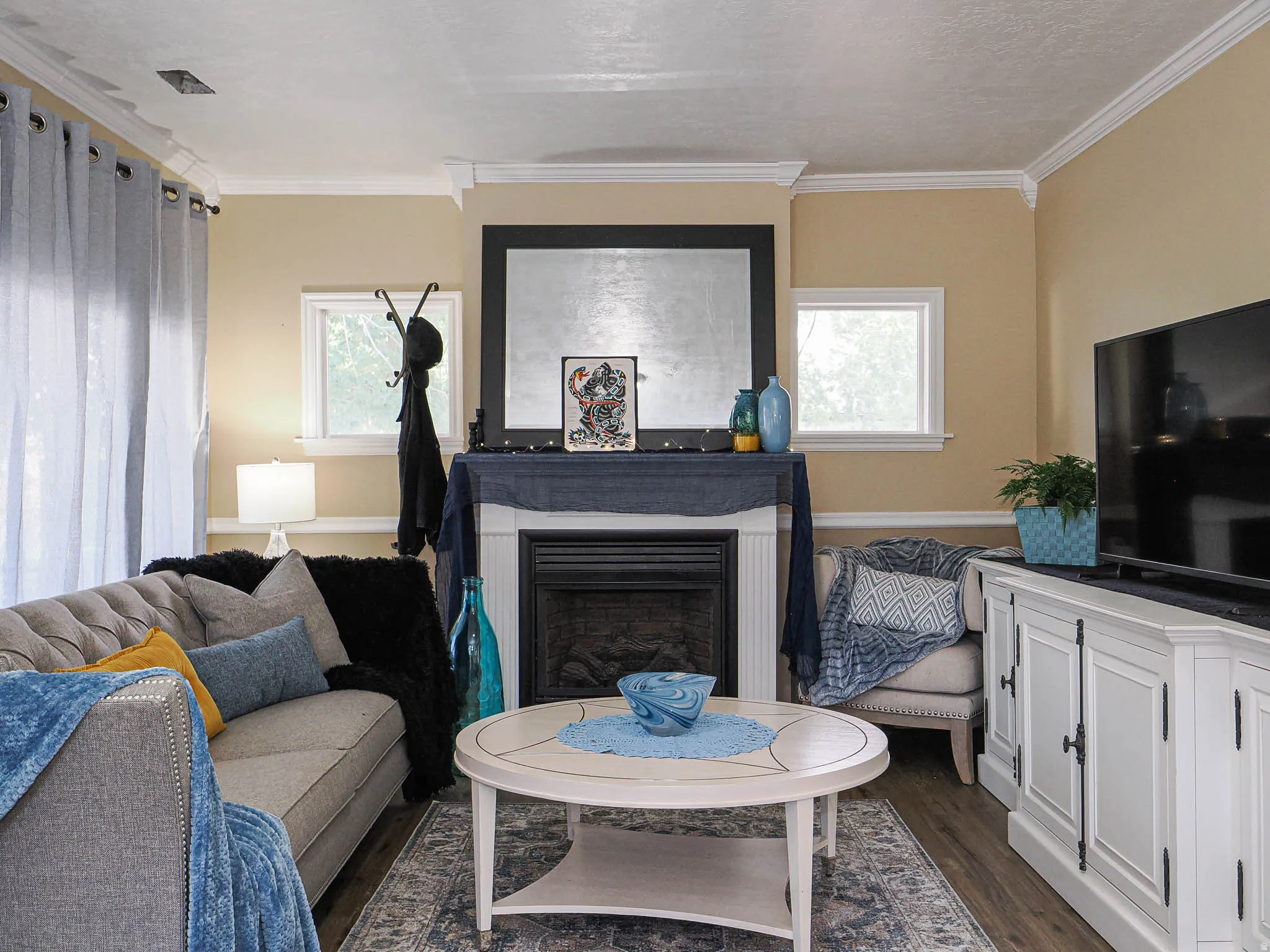 Living area featuring crown molding, neutral wall tones, and wood-finish flooring
