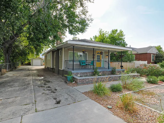 Ranch-style exterior featuring light-colored siding and a covered front porch with black railings