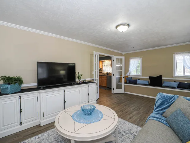 Living area featuring wood-finish flooring and crown molding