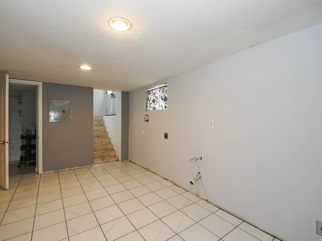Spacious room featuring tile flooring, neutral wall tones, and recessed lighting