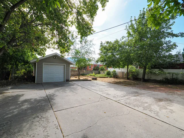 Detached garage featuring panel siding and an overhead garage door