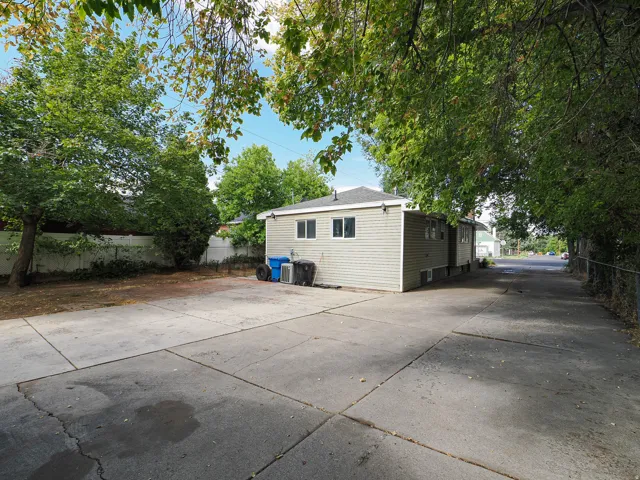 Expansive concrete driveway beside a light-colored siding structure with multiple windows