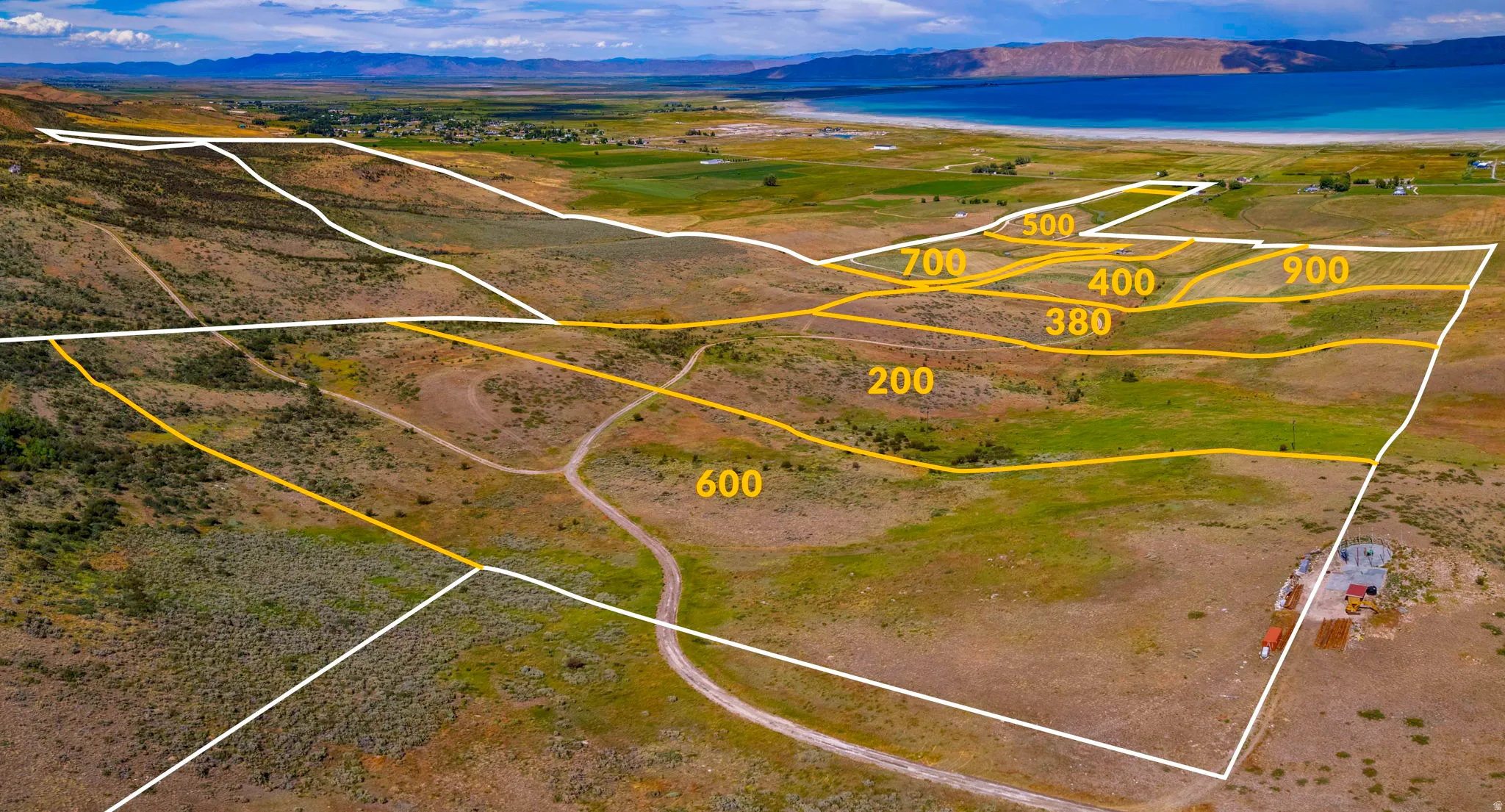 Expansive land parcels outlined by white and yellow markers, featuring varied topography