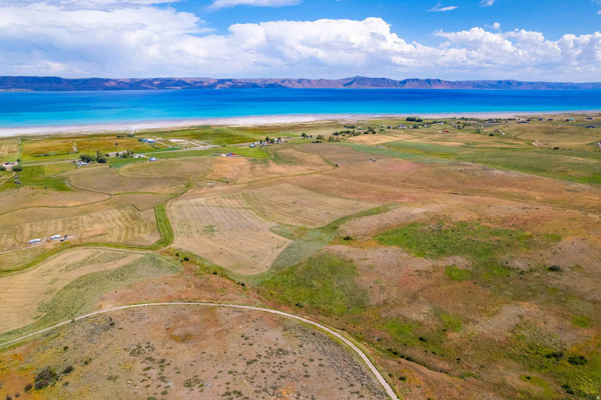 Expansive land parcel featuring natural topography, mixed vegetation, and a winding dirt path