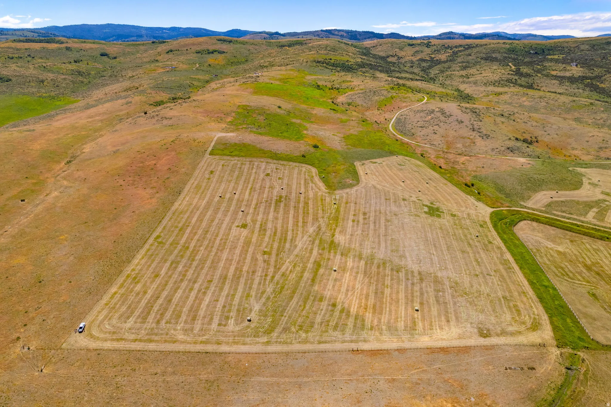 Expansive agricultural land featuring cultivated fields and a meandering unpaved road