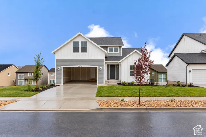 Contemporary farmhouse exterior featuring board-and-batten siding, two-tone gray and white facade, asphalt shingle roofing, and an attached two-car garage