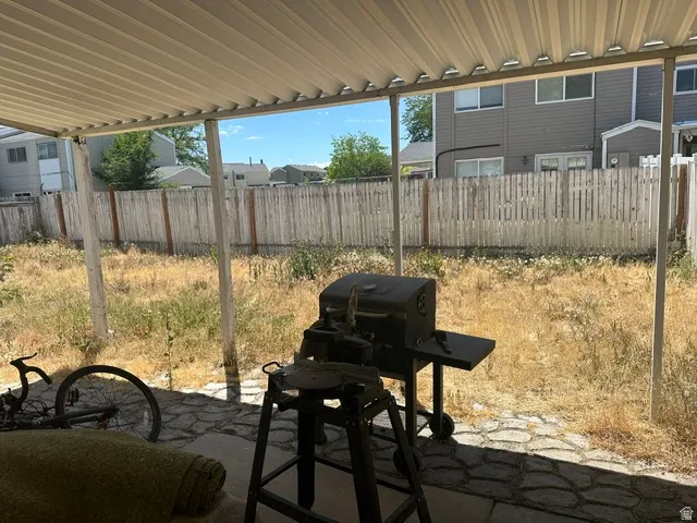 Covered patio with a stone-finish floor and a perimeter wood fence