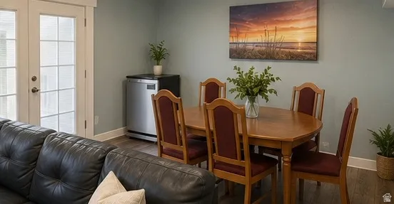 French doors with integrated blinds, wood-finish flooring, and a compact stainless steel beverage refrigerator