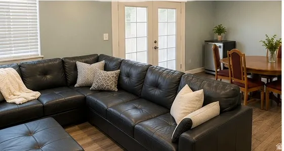 Wood-finish flooring throughout, light green wall finishes, and white French doors