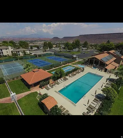 Outdoor recreational complex featuring multiple tennis courts, a large swimming pool, and dedicated lounge areas