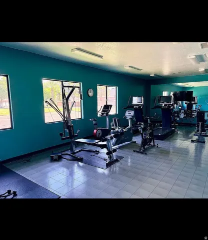 Fitness center featuring blue tiled flooring and multiple large windows