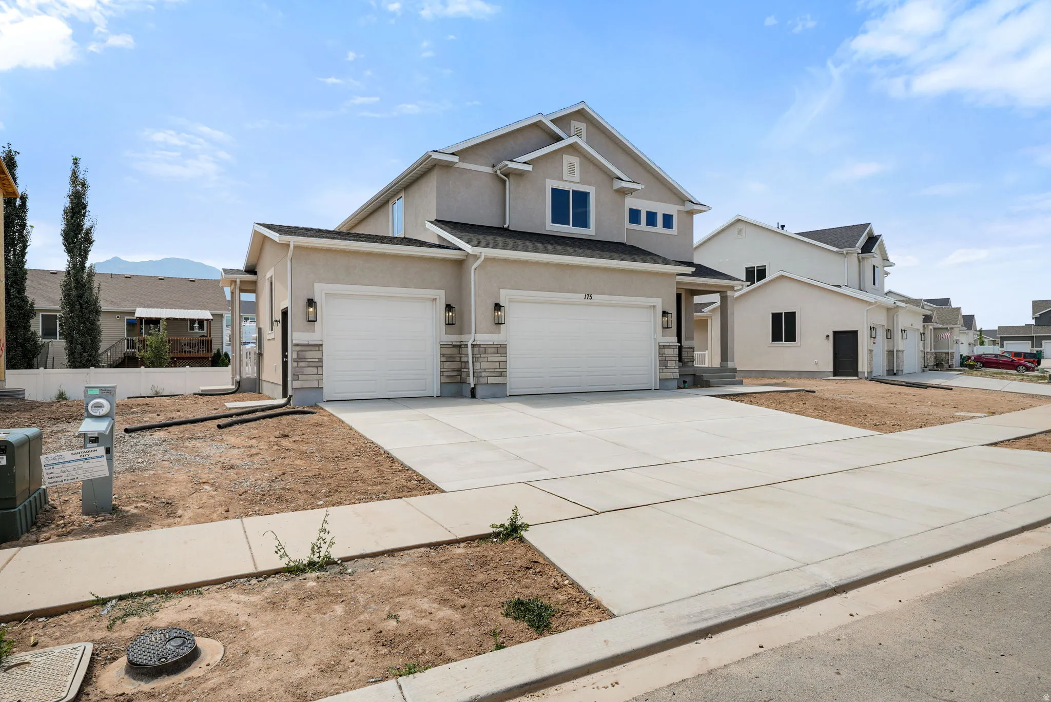 Contemporary two-story residence featuring a stucco exterior with stone accents and a covered front entry
