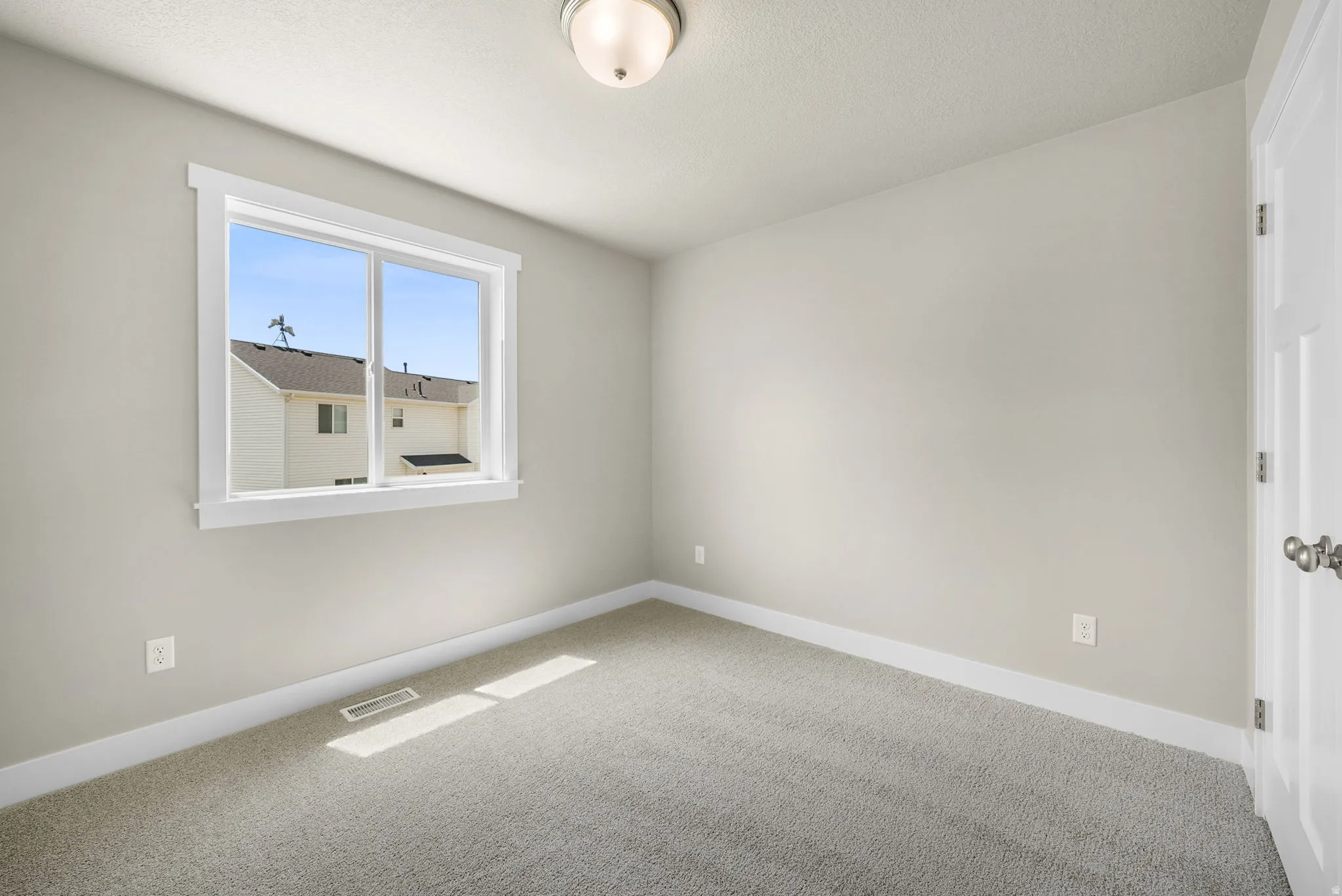 Neutral-toned walls and plush gray carpet establish a versatile interior space