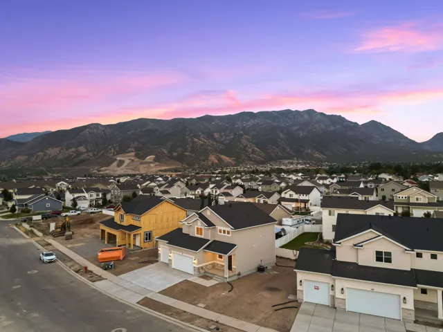New construction residential properties featuring dark shingle roofs, attached garages, and concrete driveways