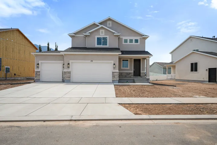 Two-story stucco exterior featuring a stone accent foundation