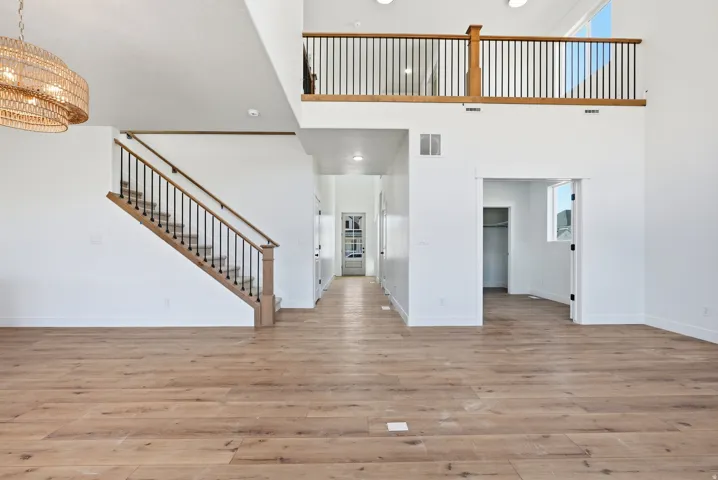 Double-height entryway featuring light wood-finish flooring
