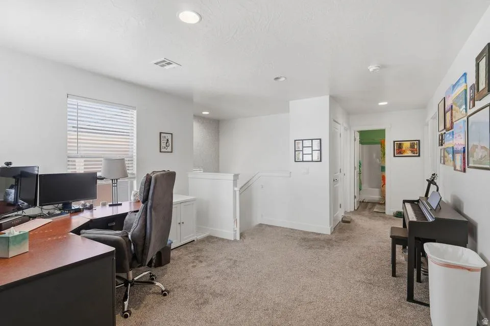 Open concept room featuring a window with blinds, light gray carpet, white walls, and recessed lighting