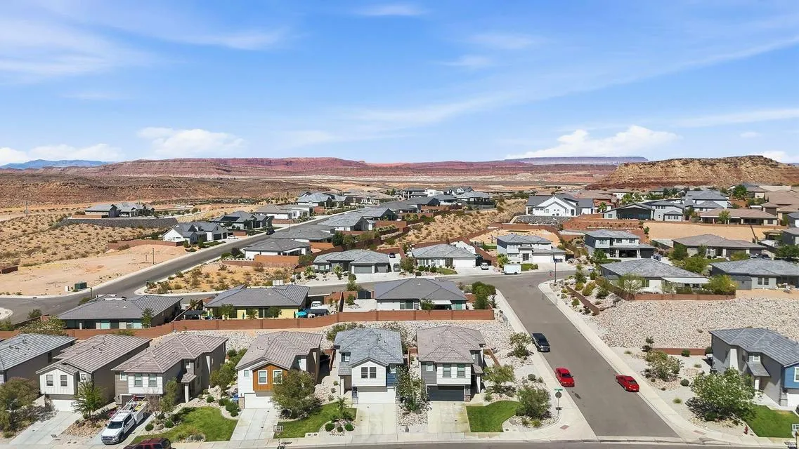 Residential development featuring varied architectural styles and desert landscaping, with distant red rock formations under a clear sky