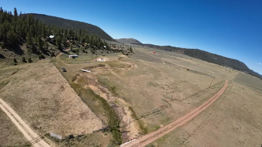 Expansive acreage featuring a dirt road, multiple outbuildings, and natural terrain