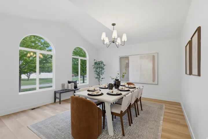Vaulted ceilings highlight a dedicated dining area featuring wood-finish flooring