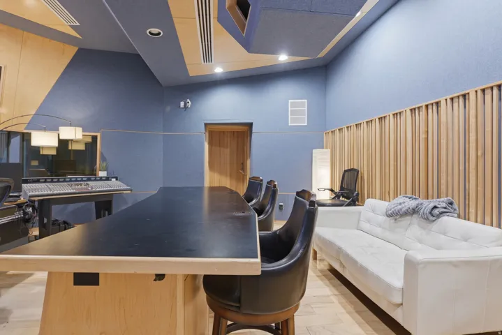 Dedicated studio space featuring acoustic paneling, wood slat wall details, recessed lighting, and a solid wood door