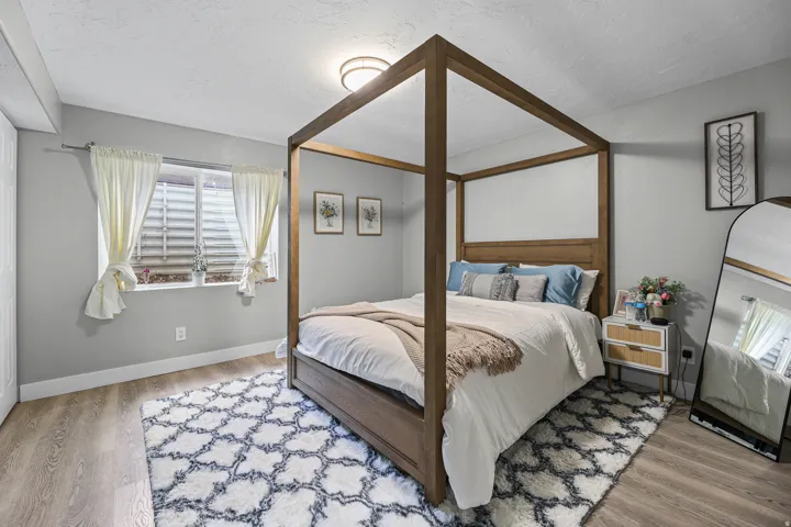 Spacious room featuring wood-finish flooring, a contemporary flush-mount ceiling light, and light gray painted walls