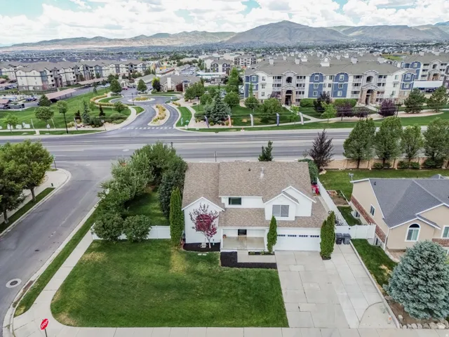 Two-story residence featuring a two-car garage, mature front yard landscaping, and a concrete driveway