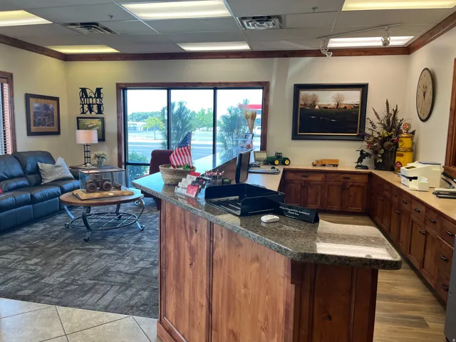 Reception area featuring a stone-look countertop, wood-finish cabinetry, and large windows