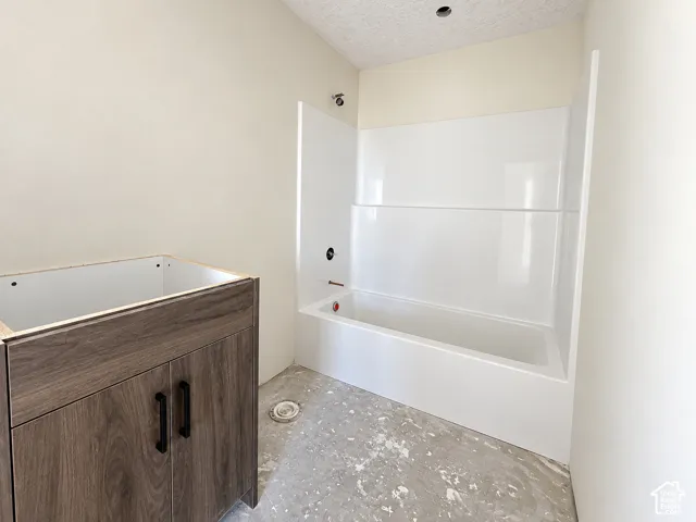 Wood-finish vanity cabinet with matte black hardware, and a white shower-tub combination-under construction
