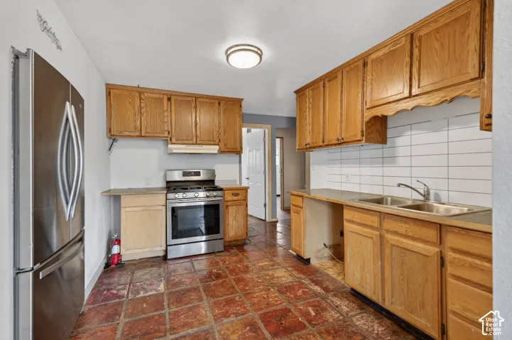 Kitchen featuring wood cabinetry, stainless steel appliances, and a double basin sink