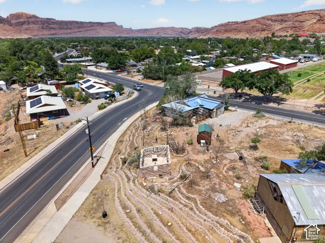 Expansive desert landscape featuring a winding road and distant red rock formations