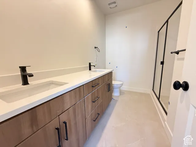 Dual sink vanity with wood-finish cabinetry, white countertop, and matte black fixtures