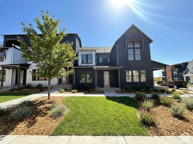 Contemporary exterior with dark siding, prominent gabled roofline, and multiple window placements